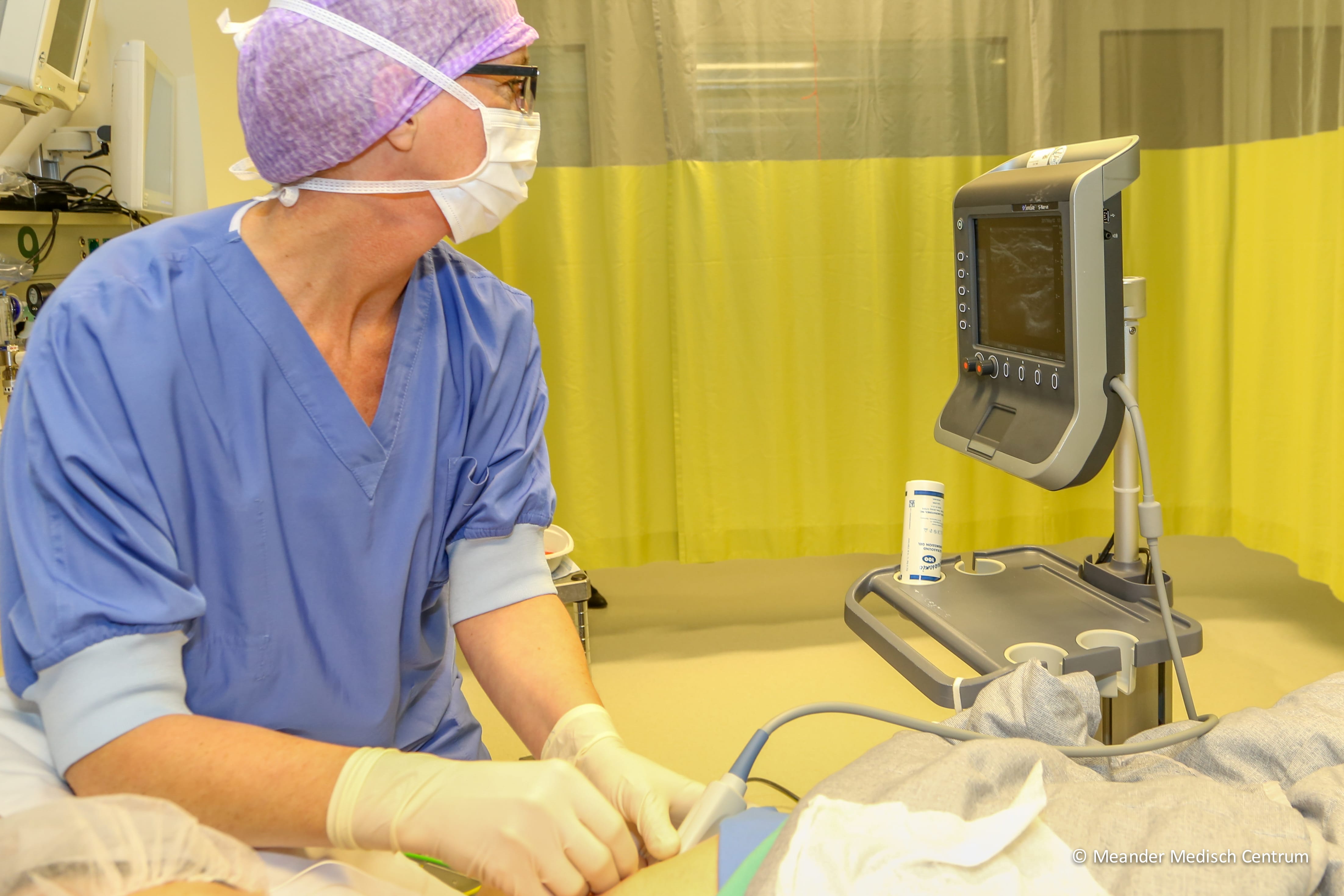 Foto: De anesthesioloog ziet op het echoscherm hoe de verdoving van het borstgebied precies op de juiste plek komt. Fotograaf: Frank Noordanus, Meander Medisch Centrum