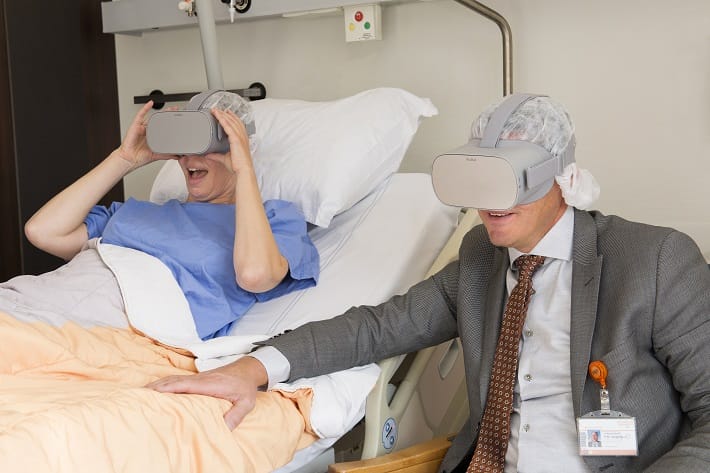 Foto: een patiënt (links) en bestuurder Peter Langenbach (rechts) genieten samen zichtbaar van een virtual reality beleving