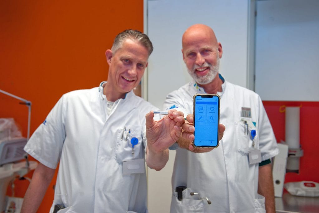 Op de foto tonen cardioloog Erwin Zegers (links) en verpleegkundig specialist Jan Elders (rechts) de hartritmemonitor en de bijbehorende app, bron: CWZ Nijmegen
